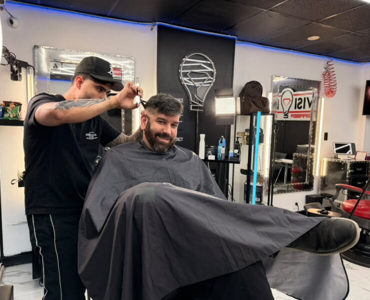 Barber cutting a client’s hair at a North Bay Village barbershop in Grandview Palace’s commercial area.