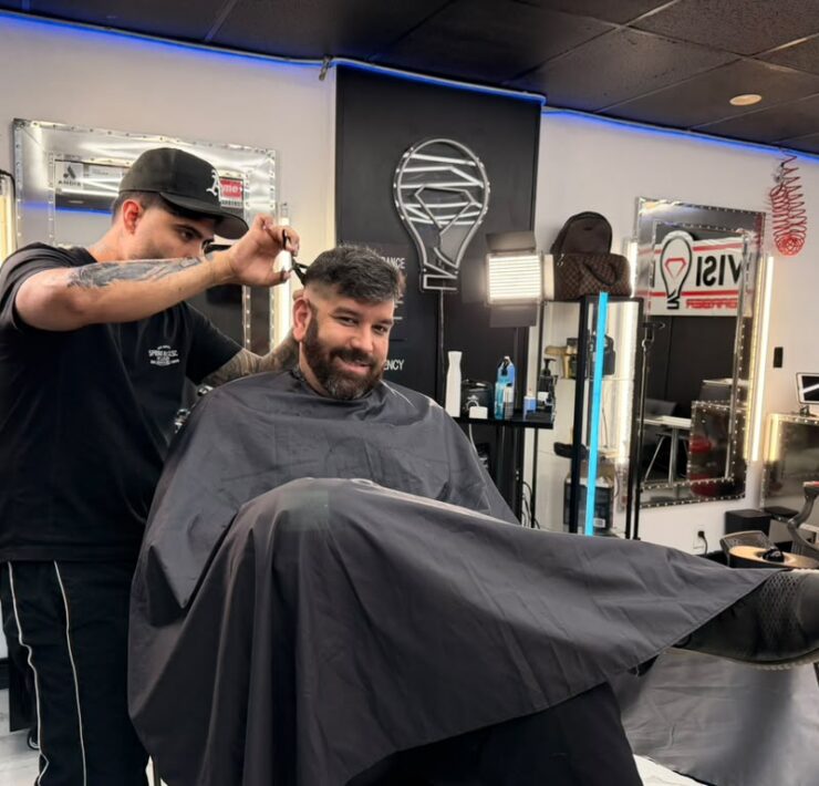 Barber cutting a client’s hair at a North Bay Village barbershop in Grandview Palace’s commercial area.